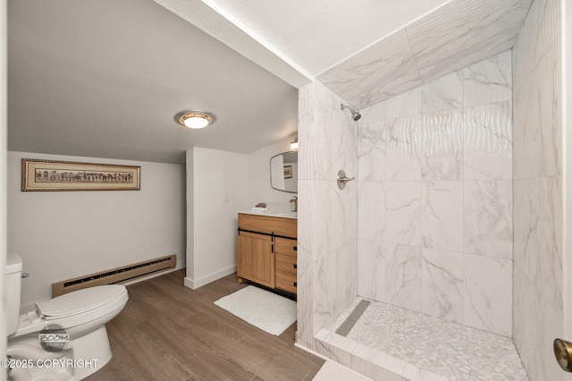900 W Selina Ln, Wasilla, AK 99654 - bathroom featuring baseboard heating, tiled shower, vanity, and wood finished floors