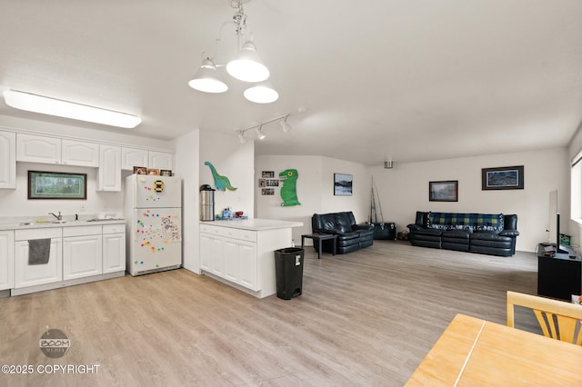 900 W Selina Ln, Wasilla, AK 99654 - kitchen featuring freestanding refrigerator, open floor plan, light countertops, white cabinets, and light wood-style floors