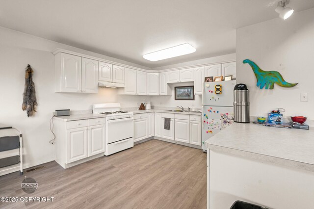 900 W Selina Ln, Wasilla, AK 99654 - kitchen with white appliances, under cabinet range hood, light countertops, and white cabinets