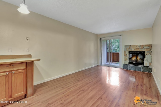 2210 Sentry Dr # B-18, Anchorage, AK 99507 - unfurnished living room with light wood-style flooring and a stone fireplace