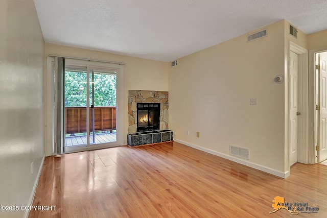 2210 Sentry Dr # B-18, Anchorage, AK 99507 - unfurnished living room featuring light wood finished floors and a fireplace