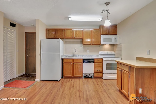 2210 Sentry Dr # B-18, Anchorage, AK 99507 - kitchen with white appliances, light countertops, tasteful backsplash, hanging light fixtures, and light wood-type flooring