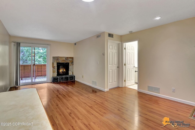 2210 Sentry Dr # B-18, Anchorage, AK 99507 - unfurnished living room with light wood-type flooring and a stone fireplace