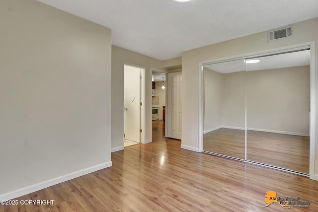 2210 Sentry Dr # B-18, Anchorage, AK 99507 - unfurnished bedroom featuring light wood-style floors and a closet