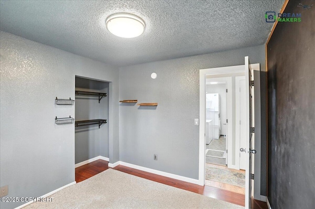 1151 W 68th Ct, Anchorage, AK 99518 - unfurnished bedroom featuring a closet, a textured ceiling, and dark wood-style flooring
