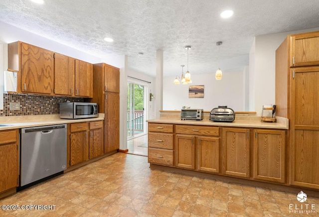 17311 Bonasila Cir, Eagle River, AK 99577 - kitchen with stainless steel appliances, brown cabinets, light countertops, a chandelier, and a textured ceiling