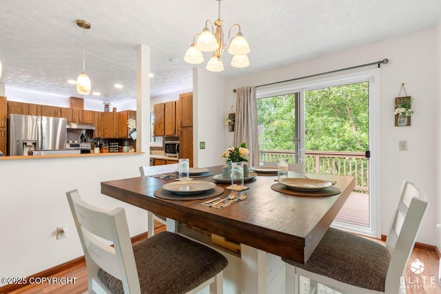 17311 Bonasila Cir, Eagle River, AK 99577 - dining area with a textured ceiling, wood finished floors, and a chandelier