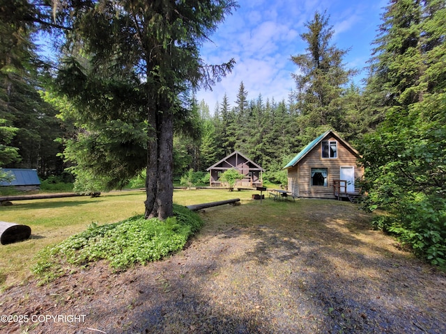 13925 Ravenquest Ave, Seward, AK 99664 - view of green lawn with an outbuilding and a view of trees