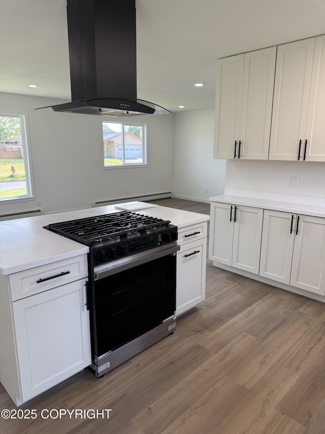 1510 Fathom Dr, Kenai, AK 99611 - kitchen with range with gas cooktop, island range hood, white cabinetry, and recessed lighting
