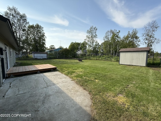 1510 Fathom Dr, Kenai, AK 99611 - fenced backyard featuring a storage shed, a wooden deck, and a patio area