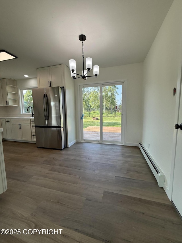 1510 Fathom Dr, Kenai, AK 99611 - unfurnished dining area featuring a baseboard heating unit, a chandelier, and dark wood-style floors