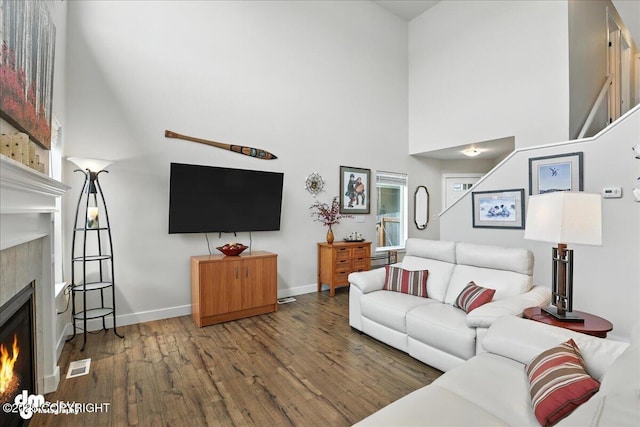 339 Skwentna Dr # 24, Anchorage, AK 99504 - living area with a lit fireplace, wood finished floors, and a towering ceiling
