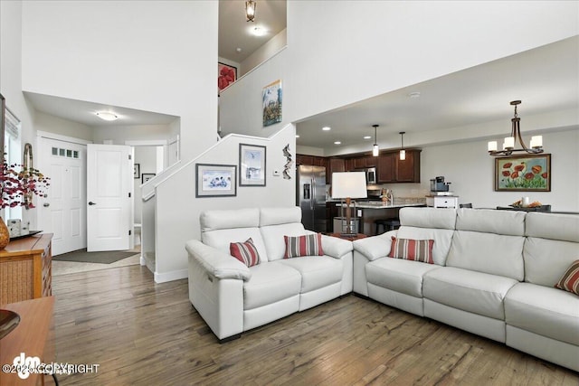 339 Skwentna Dr # 24, Anchorage, AK 99504 - living room featuring wood finished floors, a towering ceiling, and a chandelier