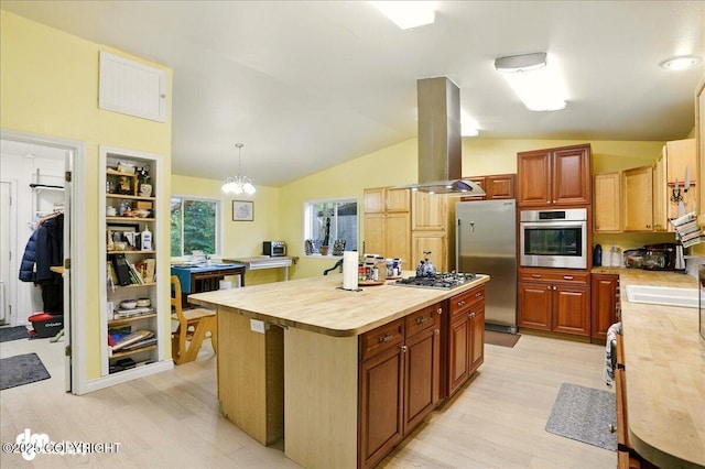 14216 W Norcross St, Big Lake, AK 99623 - kitchen featuring stainless steel appliances, island exhaust hood, light wood-style floors, vaulted ceiling, and butcher block counters