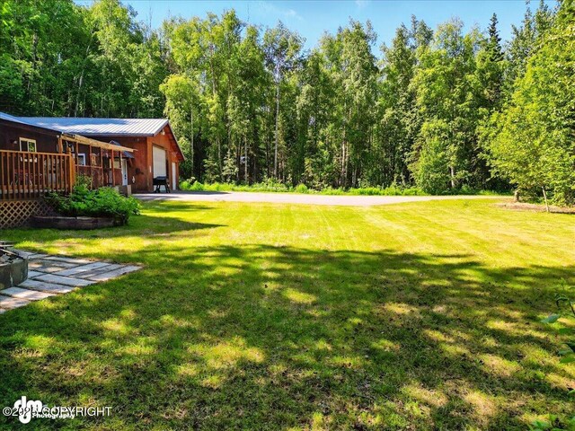 14216 W Norcross St, Big Lake, AK 99623 - view of grassy yard featuring a deck and a view of trees