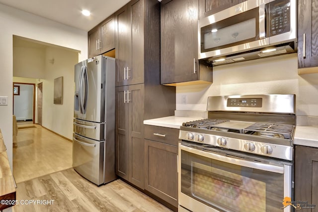 6312 Air Guard Rd, Anchorage, AK 99502 - kitchen with appliances with stainless steel finishes, light countertops, light wood-type flooring, and dark brown cabinetry