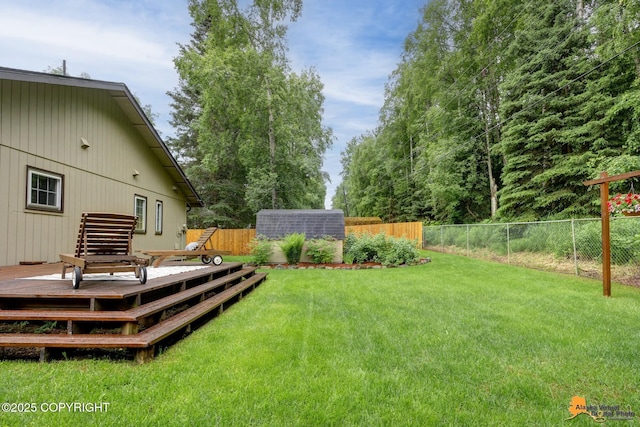 6312 Air Guard Rd, Anchorage, AK 99502 - fenced backyard with a wooden deck and an outbuilding