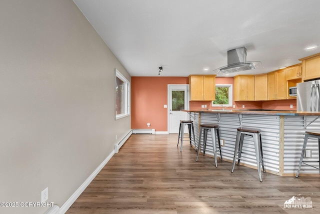 1740 Patterson Ct, Anchorage, AK 99504 - kitchen with island exhaust hood, light brown cabinets, a kitchen bar, and recessed lighting