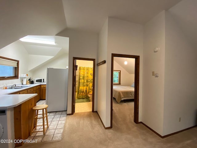 37905 Hall Rd, Sterling, AK 99672 - kitchen featuring white appliances, light countertops, brown cabinetry, lofted ceiling, and a breakfast bar area