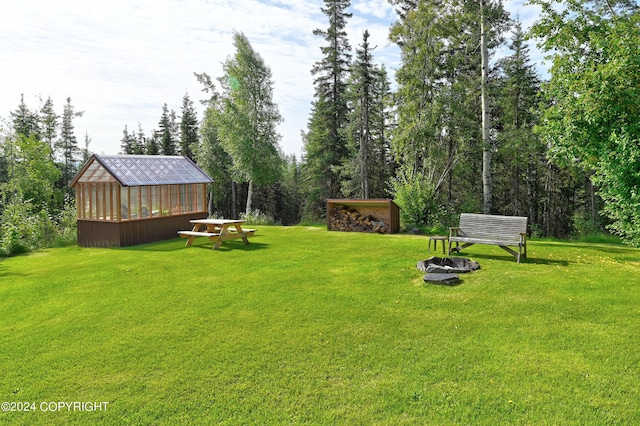 37905 Hall Rd, Sterling, AK 99672 - view of green lawn with an outbuilding, a fire pit, and an exterior structure
