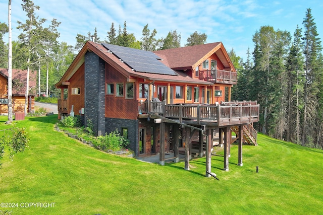 37905 Hall Rd, Sterling, AK 99672 - back of property with solar panels, stairway, a lawn, a wooden deck, and a shingled roof