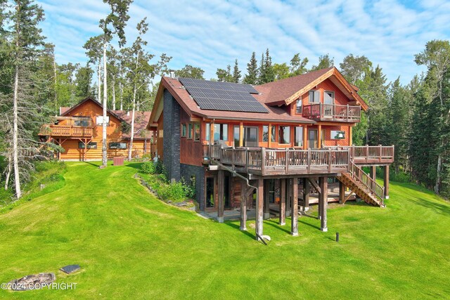 37905 Hall Rd, Sterling, AK 99672 - rear view of property featuring stairs, roof mounted solar panels, a lawn, and a wooden deck
