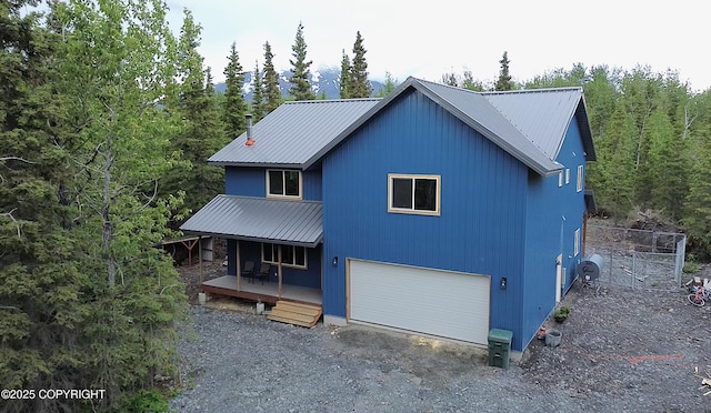 11157 S Berut Rd, Palmer, AK 99645 - view of front of property featuring covered porch, a metal roof, a garage, and a forest view