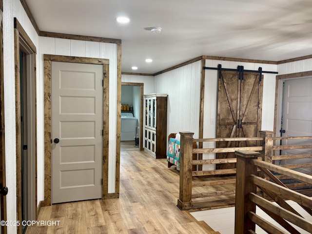 11157 S Berut Rd, Palmer, AK 99645 - corridor featuring washer / dryer, crown molding, a barn door, and light wood-type flooring