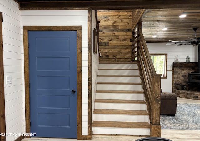 11157 S Berut Rd, Palmer, AK 99645 - staircase with a wood stove, wood finished floors, wood walls, and a ceiling fan