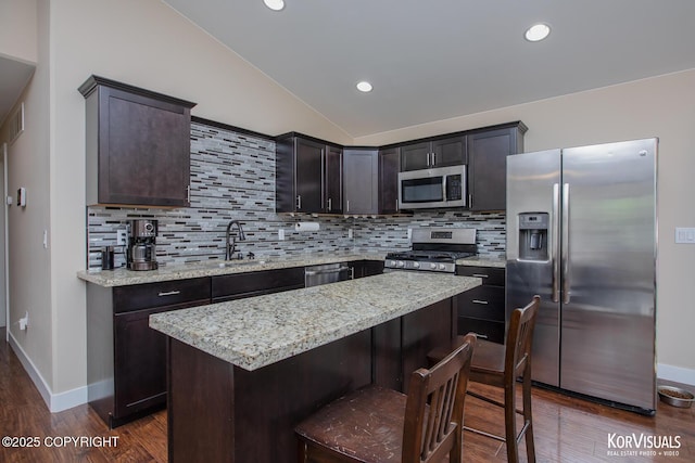 1524 N Little Susitna Dr, Wasilla, AK 99654 - kitchen featuring appliances with stainless steel finishes, vaulted ceiling, tasteful backsplash, dark wood finished floors, and a center island