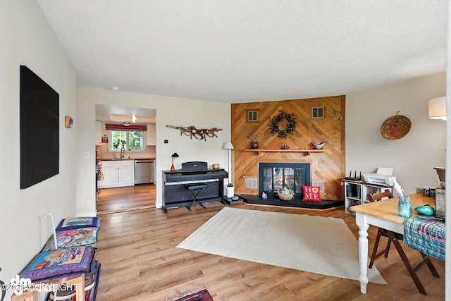222 Crest Dr, Soldotna, AK 99669 - living area with light wood-style flooring, a textured ceiling, and wood walls