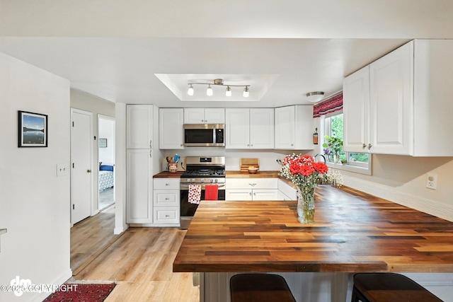 222 Crest Dr, Soldotna, AK 99669 - kitchen featuring stainless steel appliances, wooden counters, and white cabinetry