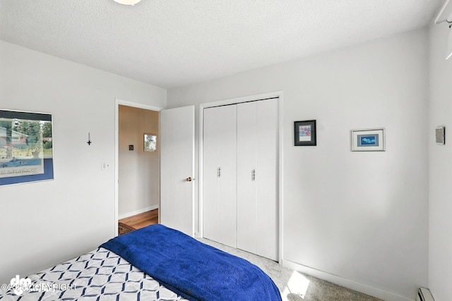 222 Crest Dr, Soldotna, AK 99669 - bedroom with baseboard heating, a closet, and a textured ceiling
