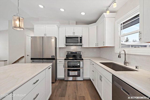 3031 Bennett Ave, Anchorage, AK 99517 - kitchen with appliances with stainless steel finishes, lofted ceiling, white cabinets, backsplash, and dark wood-style flooring