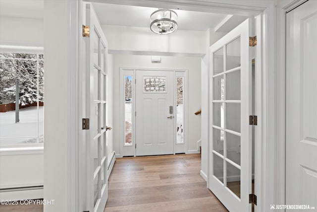 3031 Bennett Ave, Anchorage, AK 99517 - entryway with light wood-style flooring, baseboard heating, and a chandelier