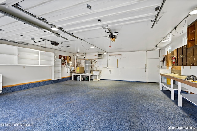 3031 Bennett Ave, Anchorage, AK 99517 - garage featuring a garage door opener, a workshop area, and water heater