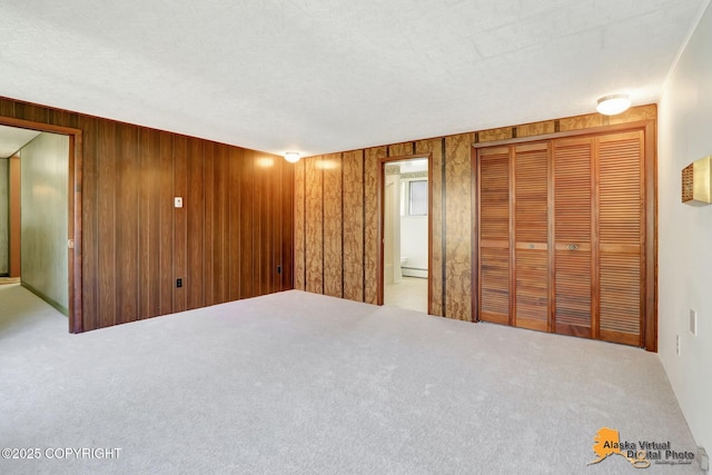 1110 F St, Anchorage, AK 99501 - unfurnished bedroom featuring carpet, a baseboard radiator, and wooden walls