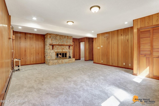 1110 F St, Anchorage, AK 99501 - unfurnished living room with a baseboard radiator, wooden walls, light colored carpet, a fireplace, and recessed lighting