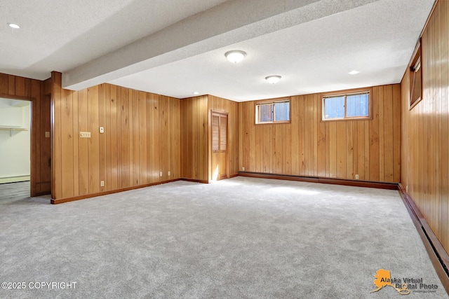 1110 F St, Anchorage, AK 99501 - basement with wood walls, carpet flooring, a baseboard radiator, a textured ceiling, and baseboard heating