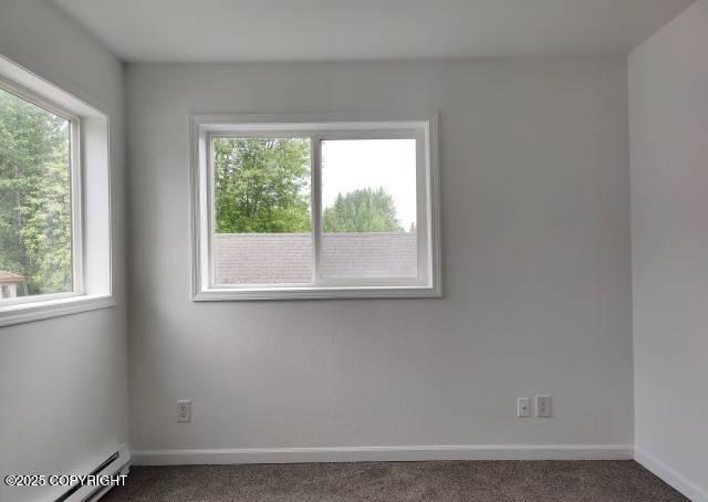 7141 Weimer Rd # 46, Anchorage, AK 99502 - carpeted empty room featuring baseboards and a baseboard heating unit