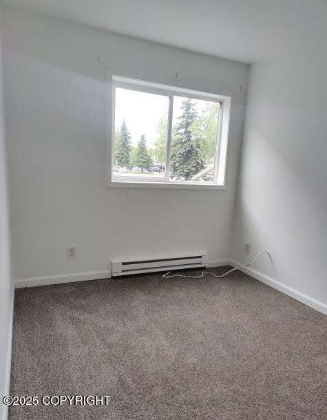 7141 Weimer Rd # 46, Anchorage, AK 99502 - carpeted empty room with a baseboard heating unit and baseboards