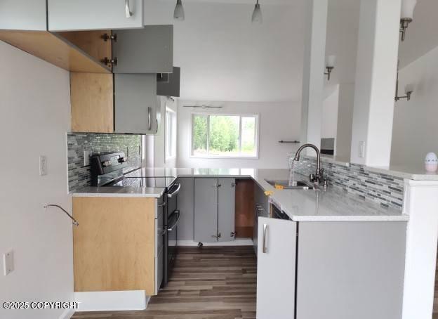 7141 Weimer Rd # 46, Anchorage, AK 99502 - kitchen featuring stainless steel electric range oven, backsplash, wood finished floors, and light countertops