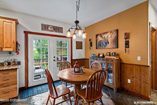 4051 Twilight Ln, Anchorage, AK 99516 - dining area with a wainscoted wall, stone tile floors, wood walls, french doors, and a chandelier