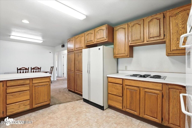 275 S Hoyt St, Anchorage, AK 99508 - kitchen featuring freestanding refrigerator, electric stovetop, light countertops, light floors, and brown cabinetry