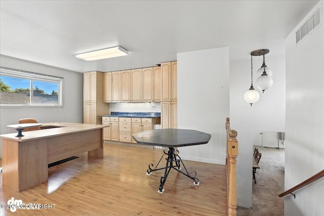 275 S Hoyt St, Anchorage, AK 99508 - kitchen featuring light brown cabinets, light wood-style floors, radiator, hanging light fixtures, and dark countertops
