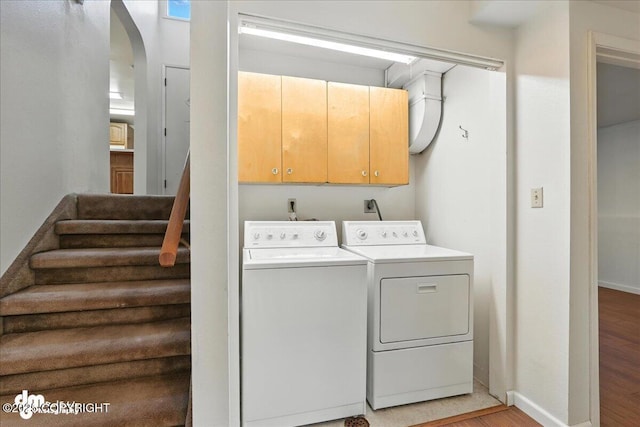 275 S Hoyt St, Anchorage, AK 99508 - laundry area with cabinet space, separate washer and dryer, arched walkways, and light wood finished floors