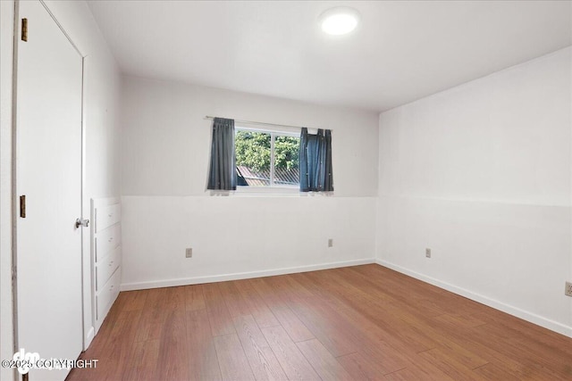 275 S Hoyt St, Anchorage, AK 99508 - unfurnished bedroom with hardwood / wood-style flooring and baseboards