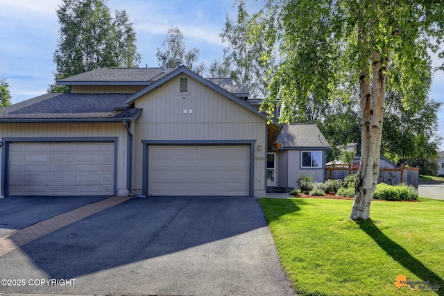 9606 Reliance Dr, Anchorage, AK 99507 - view of front facade featuring a shingled roof, asphalt driveway, a front yard, and a garage