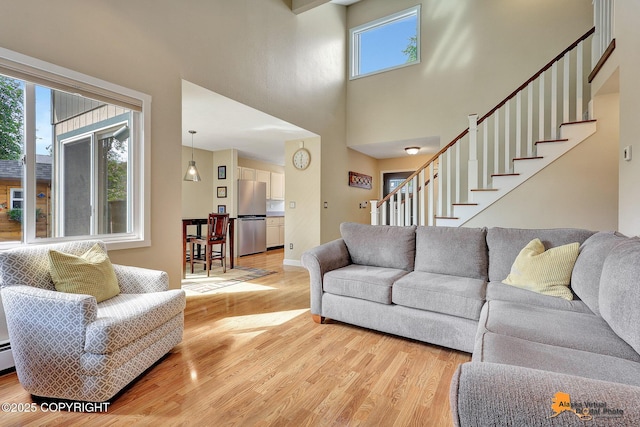 9606 Reliance Dr, Anchorage, AK 99507 - living room featuring light wood-style floors, stairway, and a towering ceiling