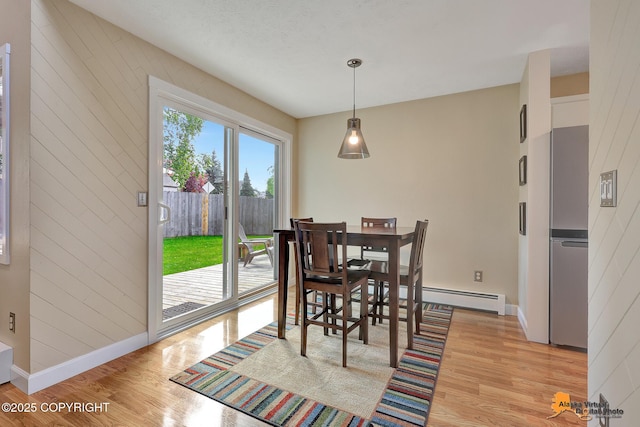 9606 Reliance Dr, Anchorage, AK 99507 - dining area with light wood-style flooring, a baseboard radiator, and wooden walls